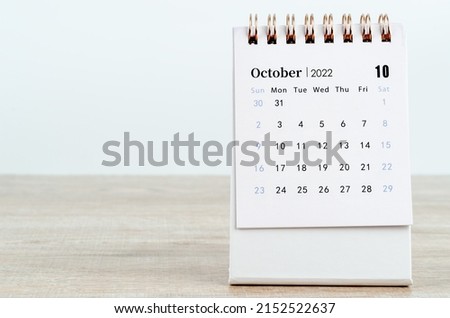 The October 2022 desk calendar on wooden background.