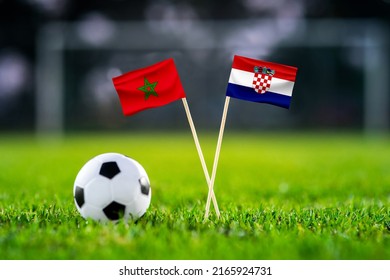 October 2022: Morocco Vs. Croatia, Wed, Nov. 23, Al Bayt, Football Match Wallpaper, Handmade National Flags And Soccer Ball On Green Grass. Football Stadium In Background. Black Edit Space.