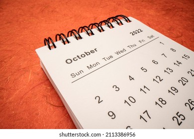 Oktober 2022 - Spiralkalender mit orangefarbenem handgefertigtem Papier, Makroaufnahme im niedrigen Winkel, Zeit- und Geschäftskonzept