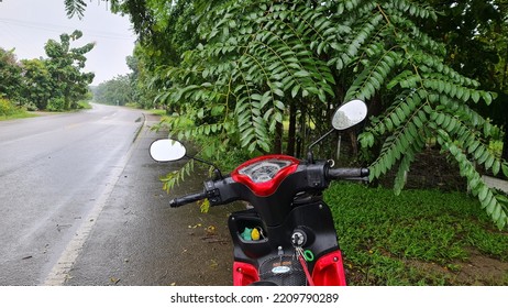 October 4 ,2022 Ratchaburi, Thailand Yamaha FINN Motorbike Trip On The Outskirts Of The City, Parked Under The Shade Of Trees Along The Road. In The Midst Of The Pouring Rain Until The Road Was Wet