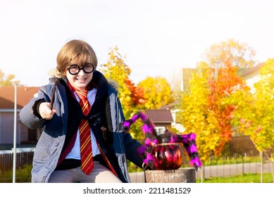 October 8, 2022. Moscow, Russia. Little Happy Boy In Harry Potter Costume With Magic Wand Sitting Outside