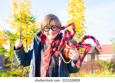 October 8, 2022. Moscow, Russia. Little Happy Boy In Harry Potter Costume With Magic Wand Sitting Outside