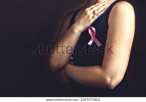 October is breast cancer awareness month,a woman\
holds a pink ribbon to support people living and sick.Health,\
international women\'s day and the concept of the world day of fight\
against cancer.