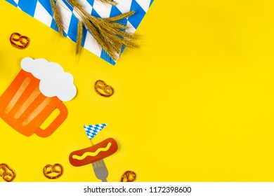 October fest concept. Wheat, germany beer, sweet tasty snacks pretzels and fork with sausage with mustard on yellow background.  Ads event of october beer festival in autumn october month. Beer day