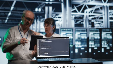 Octogenarian managers in data center, solving tasks on tablet while running scripts on laptop terminal. Adept supervisors amidst servers, accessing databases and manipulating lines of code