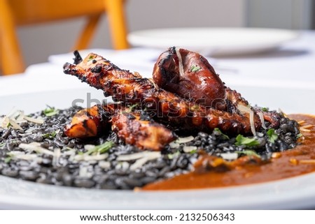 Octopus cooked in wood fire served with black ink risotto.