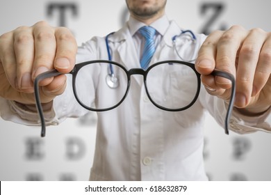 Oculist Doctor Is Offering Glasses To A Patient. Eye Sight Testing Concept.