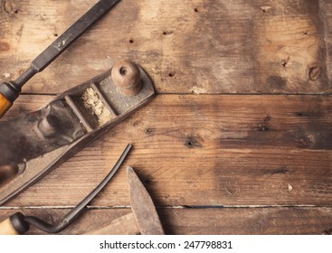 Od vintage hand tools on wooden background. Carpenter workplace.  Tinted photo