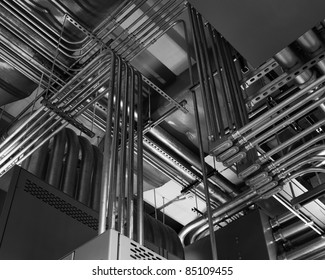 Odd angles of electrical conduits captured in black and white.  Taken in an industrial building.