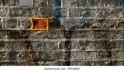 an odd brick in a wall of graffiti