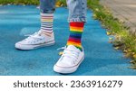 Odd Socks Day. a child in sneakers and mismatched socks stands on the playground. close-up of feet in colored socks.