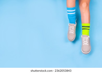 Odd Socks Day, Lonely Sock Day.  Anti-Bullying Week, Down syndrome awareness. Child legs wearing different pair of mismatched socks on high-colored background copy space - Powered by Shutterstock