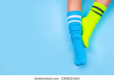 Odd Socks Day, Lonely Sock Day.  Anti-Bullying Week, Down syndrome awareness. Child legs wearing different pair of mismatched socks on high-colored background copy space - Powered by Shutterstock