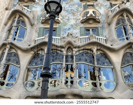 Oddly shaped windows. Skull balconies. Building facade in Barcelona. House designed by Antoni Gaudí.