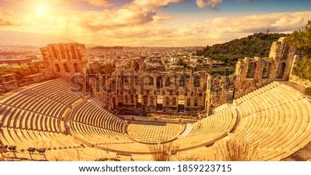 Odeon of Herodes Atticus at sunset, Athens, Greece. It is old famous landmark of Athens. Scenic panorama of ancient Greek monument overlooking Athens city. Sunny panoramic view of classical theater.
