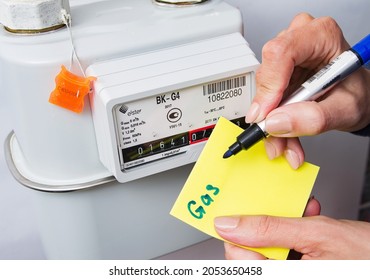 Odessa, Ukraine- 06 October 2021: Woman's Hand Writing Down The Consumption Reading Of Natural Gas At Home. Domestic Gas Meter.  