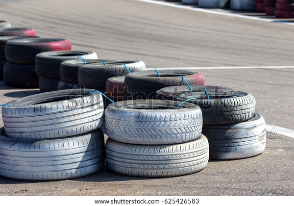 Odessa, Ukraine -10apr 2017: fragment of\
protective barrier on kart track, made of old painted tires. Many\
old car tires, tires are put in rows along highway during\
competitions auto racing on\
karting