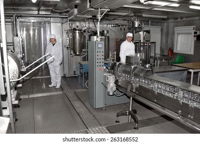 Odessa, Ukraine, April 14, 2011: Modern Food Processing Plant Produces Milk. Conveyor Line With Bottles And Cans. Workers Control Workflow 