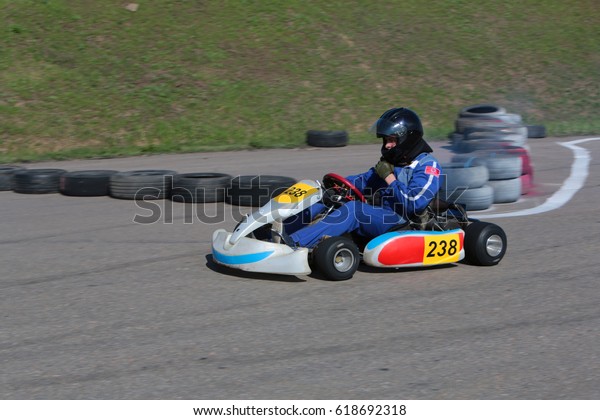 ODESSA, UKRAINE - April 2, 2017: karting\
championship. Kart drivers in helmet, racing suit participate in\
karting race. Carting show. Children, teenagers and adult kart\
racing drivers.