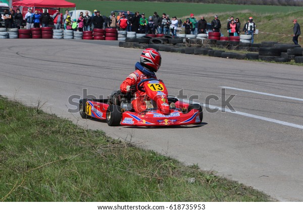 ODESSA, UKRAINE - April 2, 2017: karting
championship. Kart drivers in helmet, racing suit participate in
karting race. Carting show. Children, teenagers and adult kart
racing drivers.
