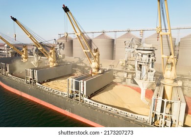ODESSA, UKRAINE - August 9, 2021: Loading grain into holds of sea cargo vessel through an automatic line in seaport from silos of grain storage. Bunkering of dry cargo ship with grain - Shutterstock ID 2173207273