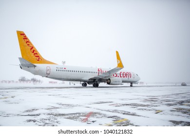 Odessa, Ukraine - CIRCA 2018: Airliner of Pegasus company on runway in blizzard. Aircraft during taxiing on landing strip during heavy snow. Passenger plane in snow at airport.