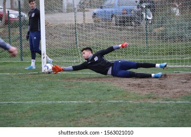 ODESSA, UKRAINE - CIRCA 2019: A Goalkeeper Of A Local Football Team Makes A Save While Playing In A Regional Derby Championship On A Bad Football Field. Soccer Goal, Goal Net