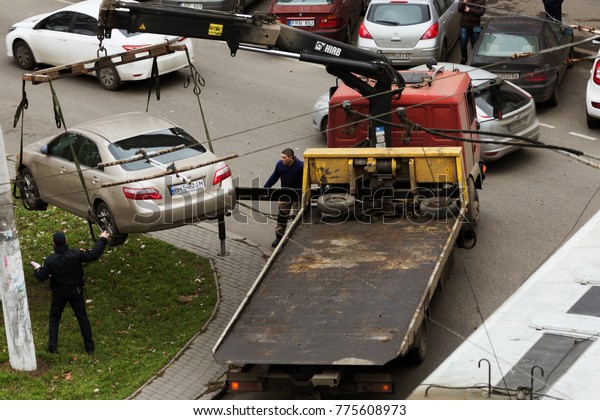 ODESSA,
UKRAINE - December 7, 2017: Traffic police officers pick up towed
car on tow truck. Car is loaded onto tug, to platform of auto tow
truck. Emergency towing of car on forklift
truck
