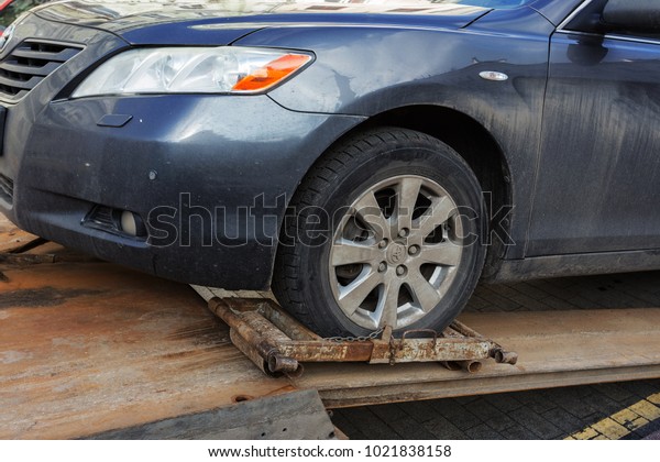 ODESSA, UKRAINE - February 10, 2018: Traffic police\
officers take towed car on tow truck. car is loaded into the tow,\
onto platform of tow truck. Emergency towing of a car on a forklift\
truck