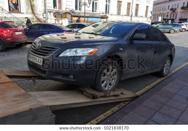 ODESSA, UKRAINE - February 10, 2018: Traffic police\
officers take towed car on tow truck. car is loaded into the tow,\
onto platform of tow truck. Emergency towing of a car on a forklift\
truck