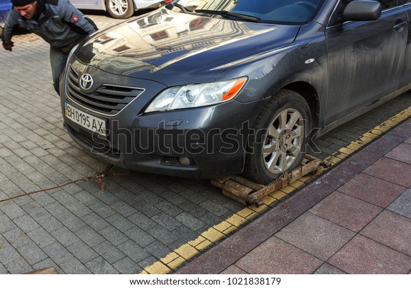 ODESSA, UKRAINE - February 10, 2018: Traffic police
officers take towed car on tow truck. car is loaded into the tow,
onto platform of tow truck. Emergency towing of a car on a forklift
truck