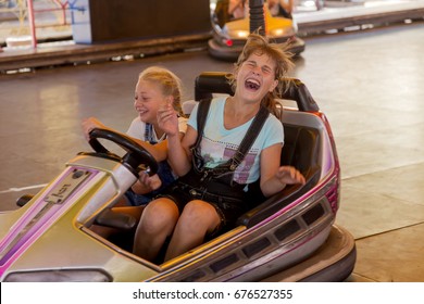 Odessa, Ukraine - July 11, 2017. A group of happy children, boys and girls happily and happily riding on an electric bumper at fairground attractions in an amusement park. Fun for parks of Luna Park