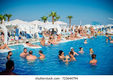 Odessa, Ukraine July 18, 2015: Ibiza Pool Party At Summer Club During Holidays Time. Enjoying Pool Party With Friends. Group Of Young People Looking Happy While Jumping Into Swimming Pool Together.