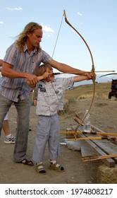 Odessa, Ukraine - July 2008 Father And Son Shooting A Bow  In Summer On Vacation 