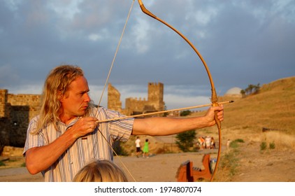 Odessa, Ukraine - July 2008 A Young Man Shooting A Bow On The Background Of An Ancient Fortress 