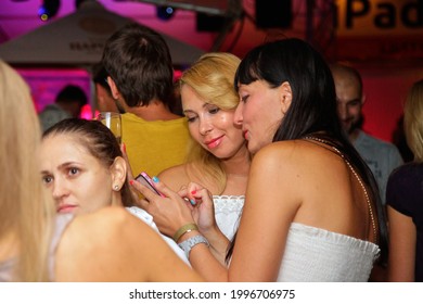 Odessa, Ukraine July 7, 2013: Ibiza Night Club. Women Smiling And Posing On Cam During Concert In Night Club Party. Girl Have Fun At Club. Girl At Night Club Party. Girl Smoke Hookan And Drink Alcohol