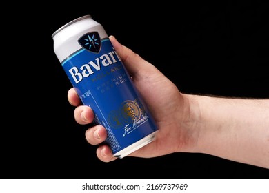 Odessa, Ukraine - June 03, 2022: A Man Offers A Can Of Beer Bavaria, Hand Holding A Can Of Beer Close-up, Black Background.