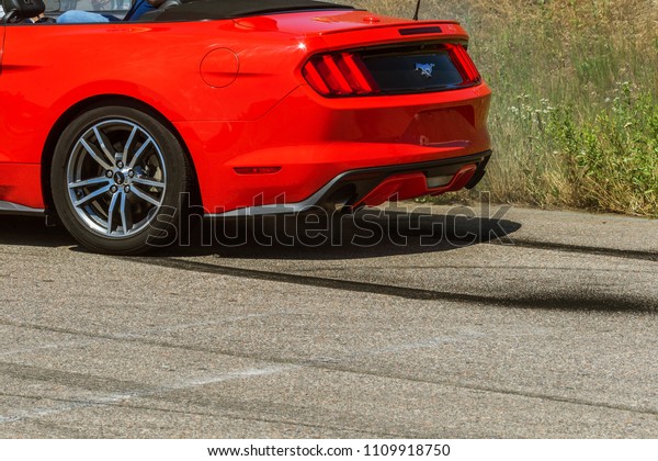 ODESSA, UKRAINE - June 10, 2018: Auto show.\
Extreme tricks, drifting on motorcycles, legendary Mustang car.\
Smoke from warming up wheels in place. Drift on site. Extreme auto\
show of speed racing