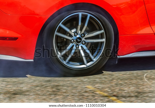 ODESSA, UKRAINE - June 10, 2018: Auto show.
Extreme tricks, drifting on motorcycles, legendary Mustang car.
Smoke from warming up wheels in place. Drift on site. Extreme auto
show of speed racing