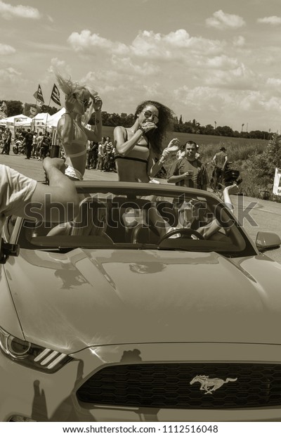 ODESSA,\
UKRAINE - June 10, 2018: Auto show. Beautiful girls present to\
spectators, the public with legendary cars, motorcycles during\
drifting with smoke on cars, motorcycle\
shows