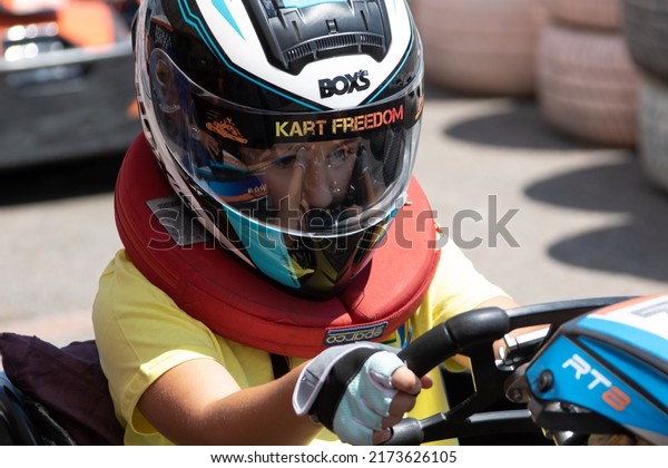 ODESSA,\
UKRAINE - June 18, 2022: Karting. Go Kart on track. Young positive\
girl racer in a helmet driving kart during car race on an auto\
track outdoors. Extreme auto sport in sports\
club