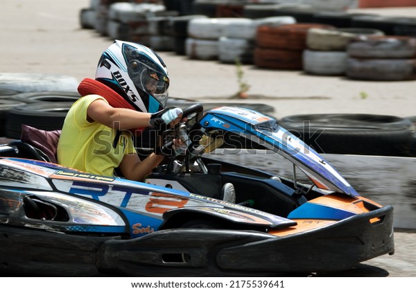 ODESSA,\
UKRAINE - June 18, 2022: Karting. Go Kart on track. Young positive\
girl racer in a helmet driving kart during car race on an auto\
track outdoors. Extreme auto sport in sports\
club