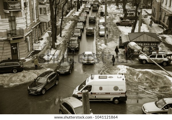 ODESSA, UKRAINE - March 7, 2018: Traffic jam in an\
hour-peak on small square as result of improper car parking. Police\
evacuate car violator parking rules. Top view from a bird\'s flight.\
Car jam