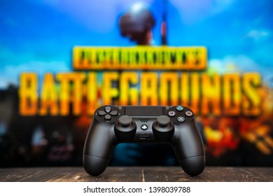 Odessa, Ukraine - May 12, 2019. Black Playstation 4 Gamepad On The Background Of The Game PUBG.  PLAYERUNKNOWN'S BATTLEGROUNDS  Battle Royale Shooting Game.