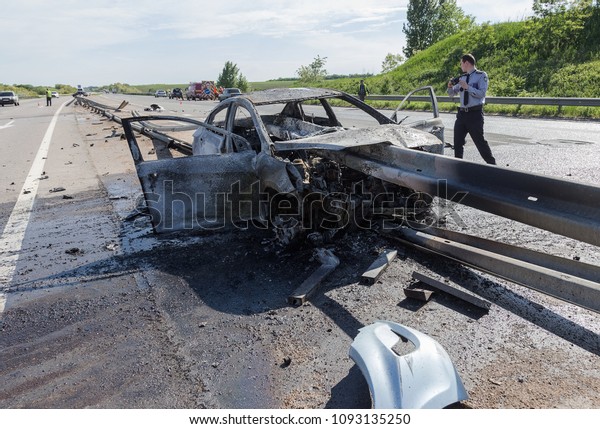 ODESSA, UKRAINE - May 17, 2018: accident on\
high-speed road. Car at high speed drove to road guard and burned.\
Terrible tragic accident due to speeding. Auto crashed into\
separating road safety\
guard