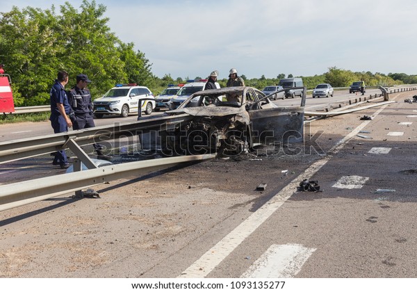 ODESSA, UKRAINE - May 17, 2018: accident on\
high-speed road. Car at high speed drove to road guard and burned.\
Terrible tragic accident due to speeding. Auto crashed into\
separating road safety\
guard