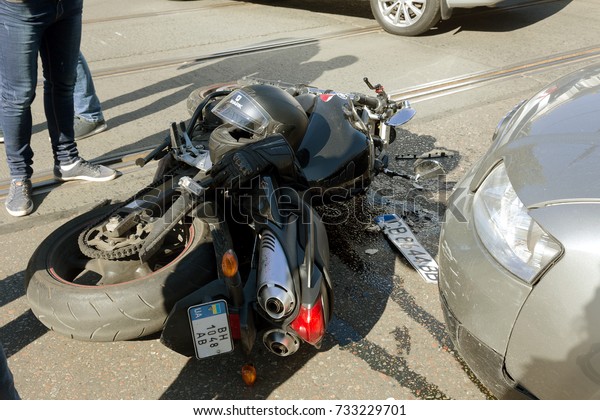 ODESSA, UKRAINE - October 11,2017: an easy accident\
between car and motorcycle. bike crashed into car. He lost control\
of  wet asphalt. First aid, police, insurance agent. motorcycle\
accident with car