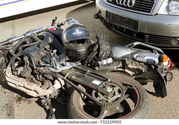 ODESSA, UKRAINE - October 11,2017: an easy accident\
between car and motorcycle. bike crashed into car. He lost control\
of  wet asphalt. First aid, police, insurance agent. motorcycle\
accident with car