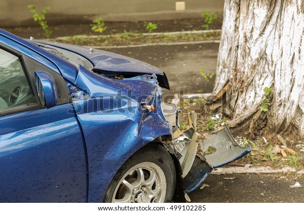 Odessa, Ukraine - October 14, 2016: Car during\
the day in the rain at high speed flew over the barrier of\
pedestrian crossing and crashed into standing tree. Car accident in\
city. Head-on collision