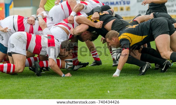 ODESSA, UKRAINE - Okt 20,\
2017: Rugby Championship national team of Odessa - Kharkov. Intense\
struggle of players in rugby for ball. Dynamic game on green field\
of stadium